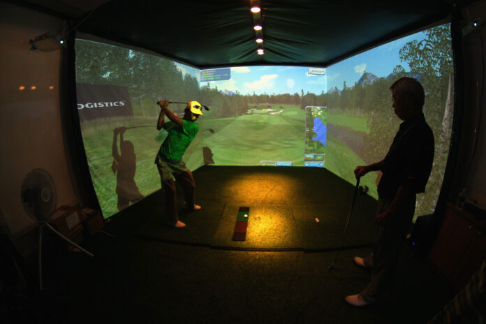Kaksi miestä käyttää Golf Simulator.